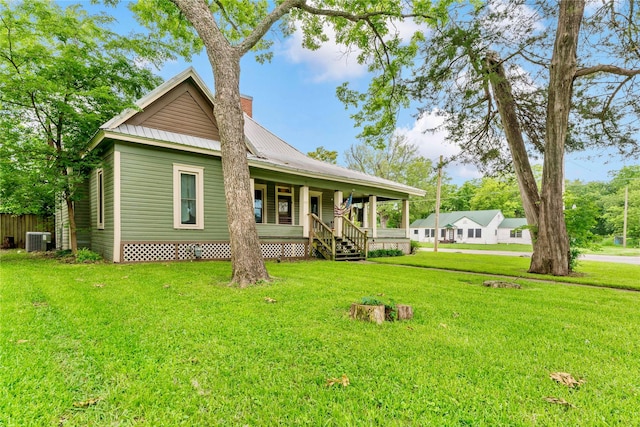 back of house featuring a lawn, central air condition unit, and covered porch