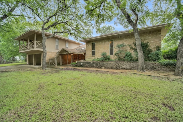 view of front of house with a balcony and a front yard