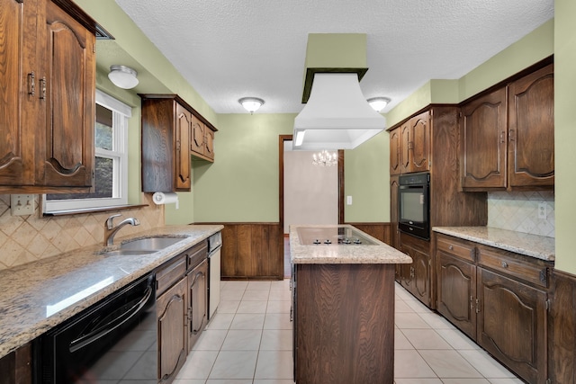 kitchen with black appliances, decorative backsplash, a center island, and sink