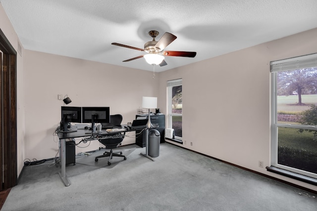 carpeted office featuring a textured ceiling, ceiling fan, and a healthy amount of sunlight