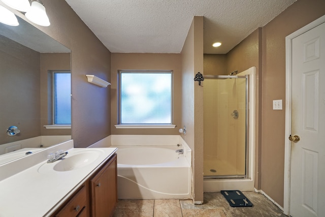 bathroom with tile patterned floors, vanity, a textured ceiling, and plus walk in shower