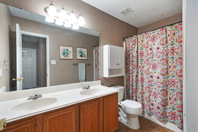 bathroom with a shower with curtain, tile patterned flooring, a textured ceiling, toilet, and vanity