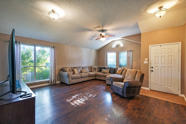 living room with a textured ceiling, dark hardwood / wood-style flooring, a healthy amount of sunlight, and lofted ceiling