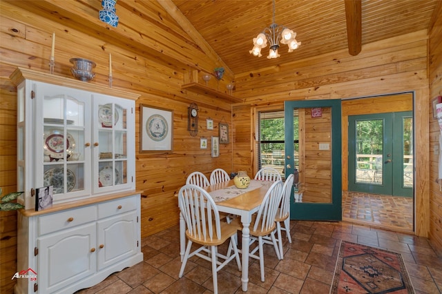 dining area with vaulted ceiling, french doors, wood ceiling, wood walls, and a chandelier