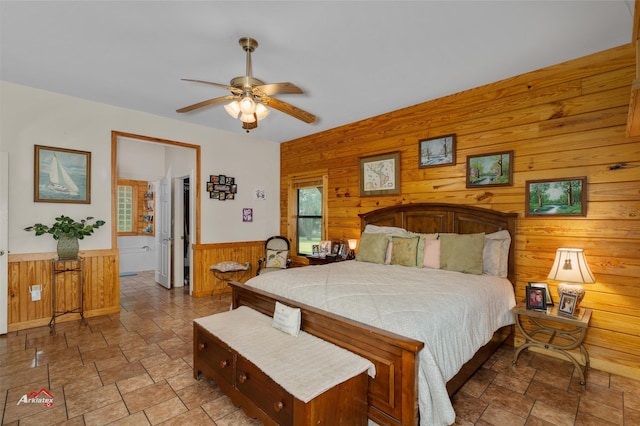 bedroom featuring ceiling fan and wooden walls