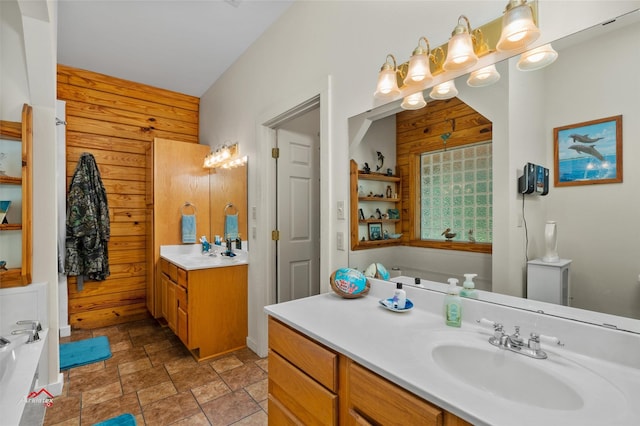 bathroom with a bath, wood walls, and vanity