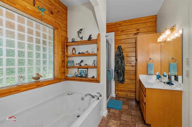 bathroom featuring vanity, a bath, and wooden walls