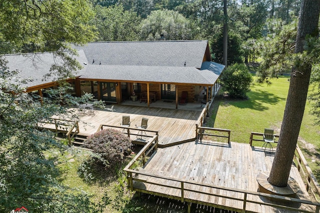 rear view of house with a wooden deck and a lawn