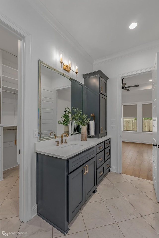 bathroom with ceiling fan, vanity, and ornamental molding