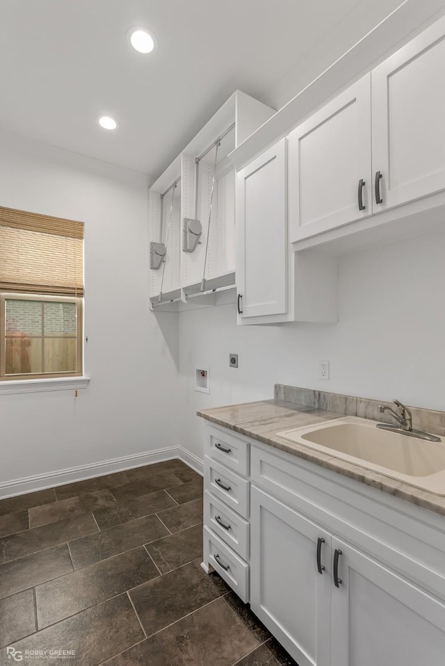 clothes washing area featuring sink, hookup for a washing machine, electric dryer hookup, and cabinets