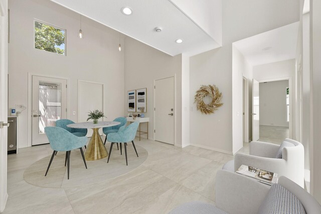 tiled dining area with a towering ceiling