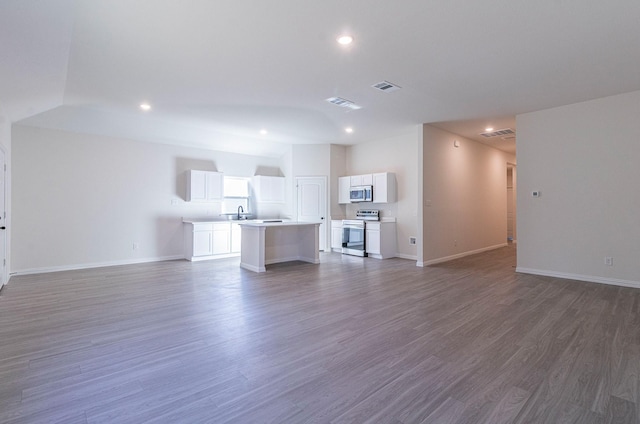 unfurnished living room featuring dark wood-type flooring and sink