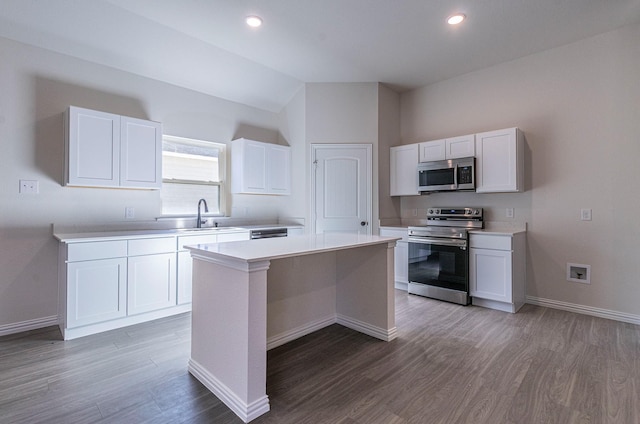 kitchen featuring appliances with stainless steel finishes, a center island, white cabinets, and dark hardwood / wood-style flooring