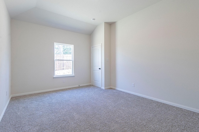 empty room with lofted ceiling and carpet