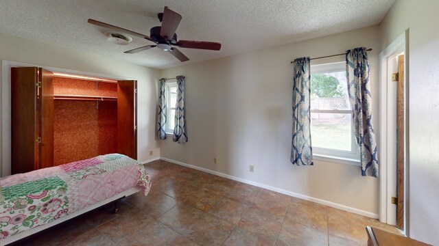 203 Mesa Dr, Gatesville, TX 76528 - bedroom featuring ceiling fan, baseboards, a closet, and a textured ceiling