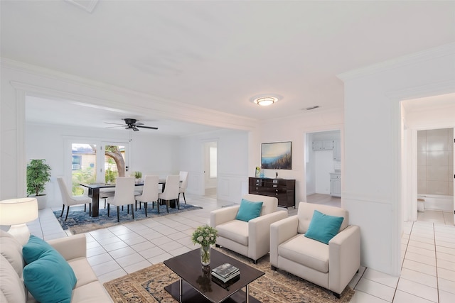 living room with crown molding, ceiling fan, and light tile patterned floors