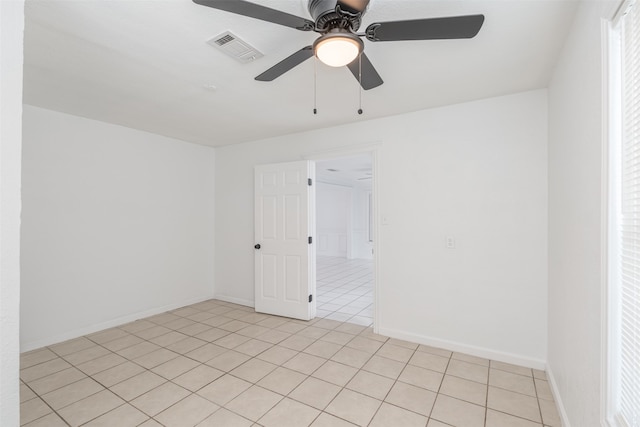 tiled empty room featuring ceiling fan