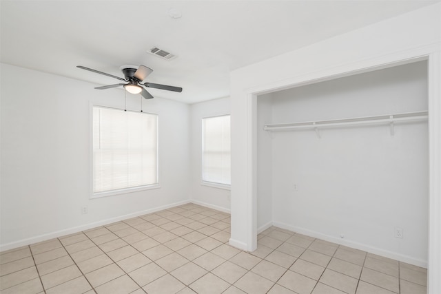 unfurnished bedroom featuring ceiling fan, a closet, and light tile patterned floors