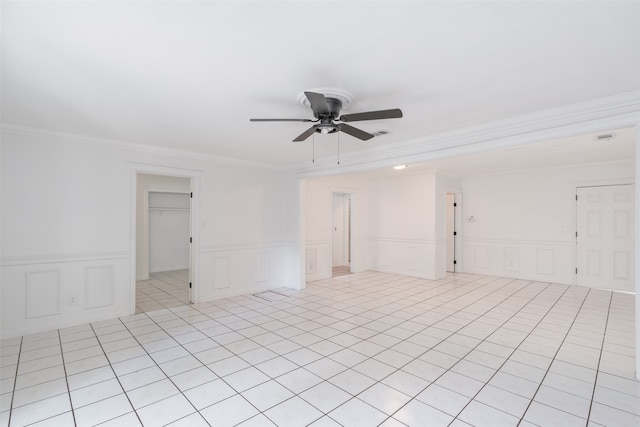 empty room with crown molding, ceiling fan, and light tile patterned floors