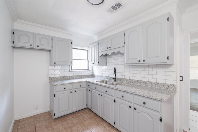 kitchen with crown molding, white cabinetry, and sink