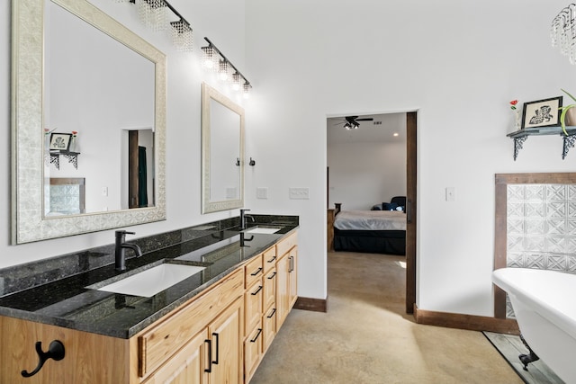 bathroom featuring double sink, ceiling fan, a tub, and vanity with extensive cabinet space