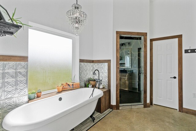 bathroom featuring a chandelier and a tub to relax in