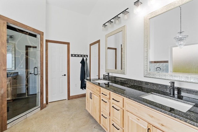 bathroom featuring vanity, an enclosed shower, and a chandelier