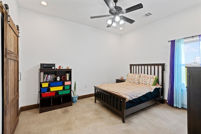 bedroom with carpet flooring, a barn door, and ceiling fan