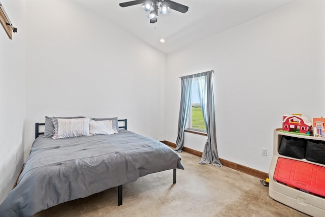 bedroom featuring ceiling fan, vaulted ceiling, and light carpet