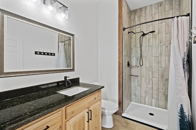 bathroom featuring tile floors, walk in shower, vanity with extensive cabinet space, and toilet