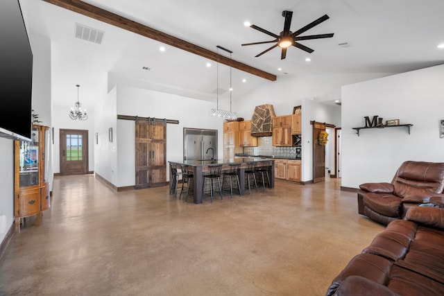 living room with a barn door, ceiling fan with notable chandelier, beamed ceiling, and high vaulted ceiling