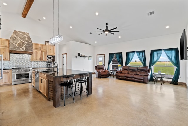 kitchen with stainless steel appliances, backsplash, ceiling fan, an island with sink, and sink