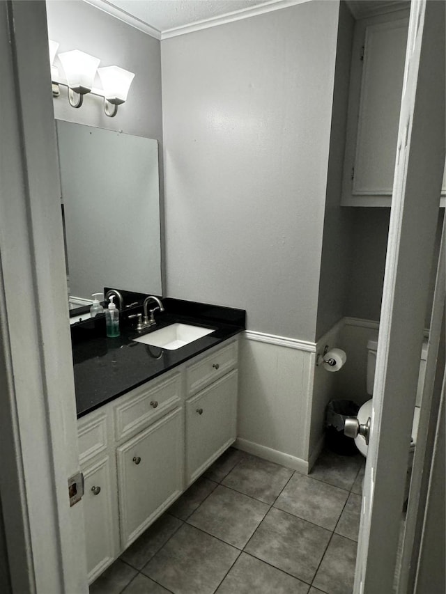 bathroom with tile patterned floors, vanity, toilet, and ornamental molding