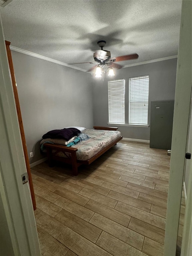 bedroom with a textured ceiling, light hardwood / wood-style flooring, ceiling fan, and crown molding