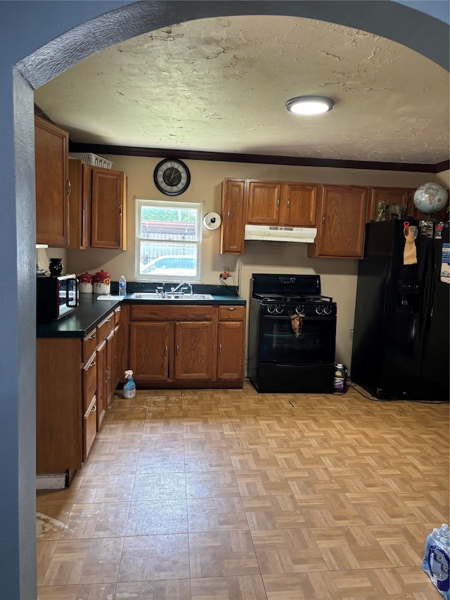 kitchen with sink, light parquet floors, a textured ceiling, and black appliances