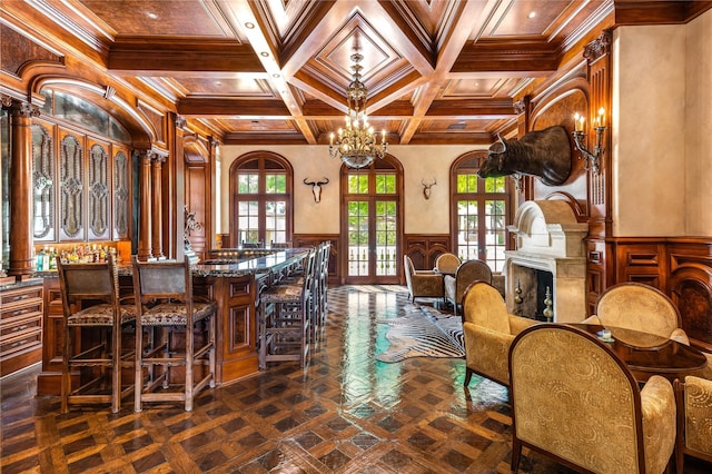 dining space featuring beam ceiling, coffered ceiling, ornamental molding, french doors, and a chandelier