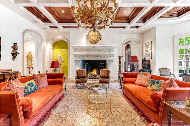 living room featuring crown molding, coffered ceiling, a premium fireplace, and a chandelier