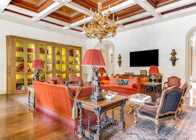 living room with beamed ceiling, coffered ceiling, an inviting chandelier, and hardwood / wood-style floors