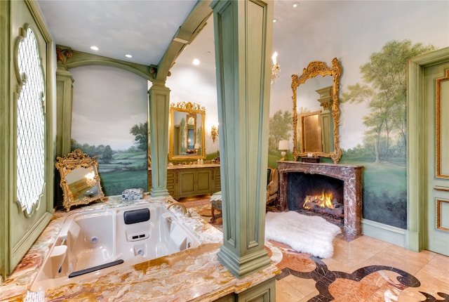 bathroom featuring tile flooring, decorative columns, vanity, and a high end fireplace