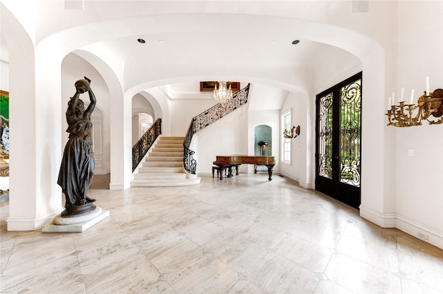 foyer entrance with a notable chandelier, french doors, and light tile flooring