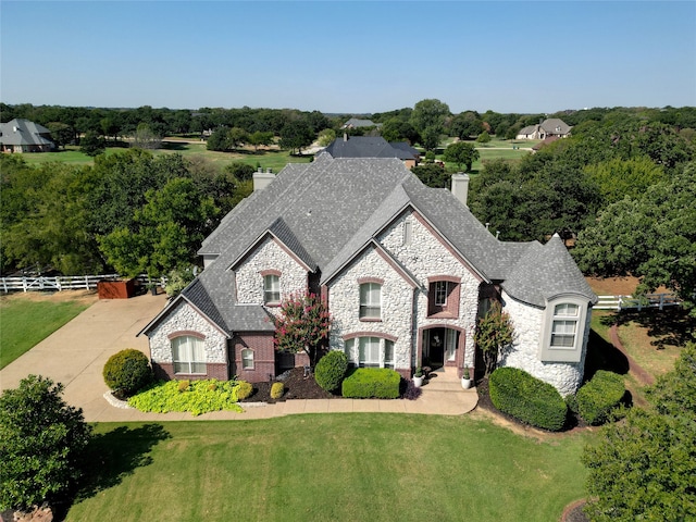 french country inspired facade featuring a front lawn