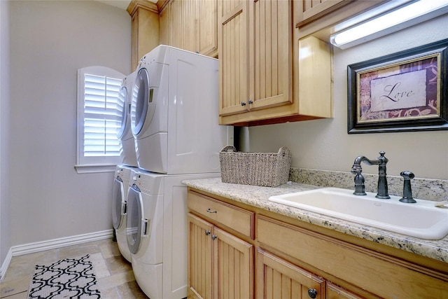 washroom with stacked washer / dryer, cabinets, sink, and light tile patterned floors