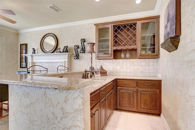 bar featuring light stone counters, ornamental molding, sink, and ceiling fan