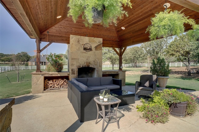 view of patio with a gazebo and an outdoor living space with a fireplace