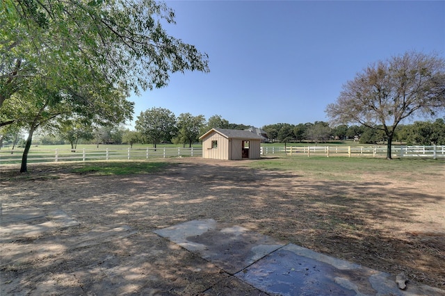 view of yard with a storage unit and a rural view