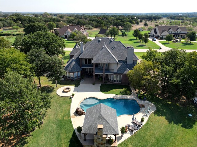 back of house featuring a balcony, a patio area, and a lawn