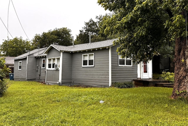 back of property featuring cooling unit and a lawn