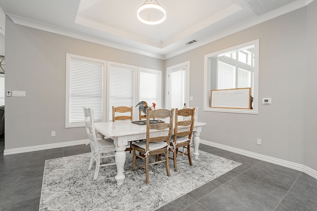 tiled dining room with a raised ceiling