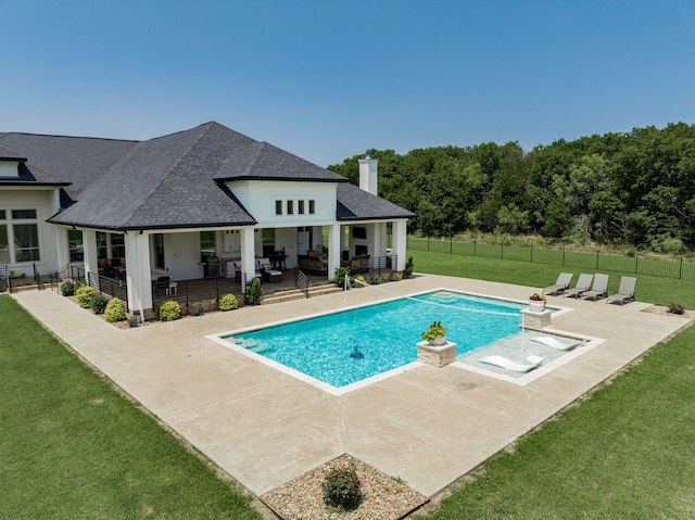 view of pool with a patio area and a lawn