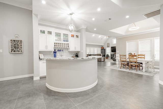 kitchen featuring white cabinets, light stone countertops, tile floors, and pendant lighting